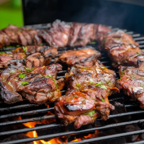 a close up of Nyama Choma cooking on a grill
